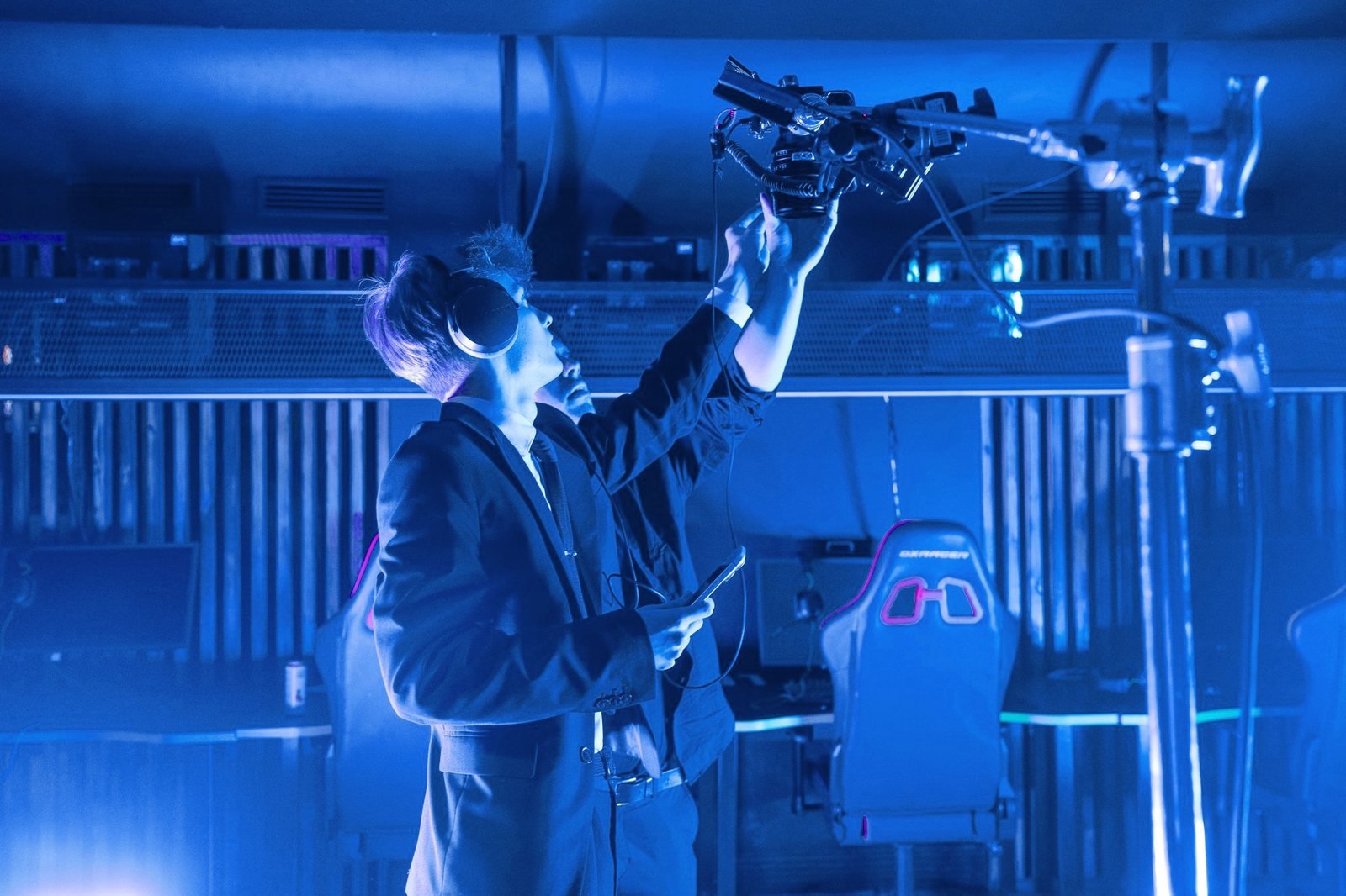 A crew member rigs a camera overhead on a stand.