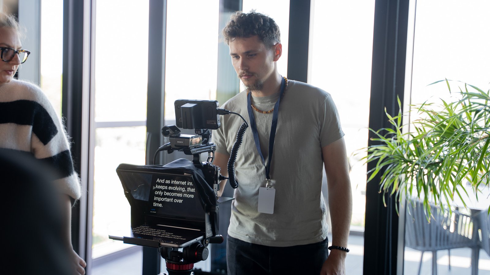 Sony camera on a teleprompter rig during an interview shoot in a glass-walled office
