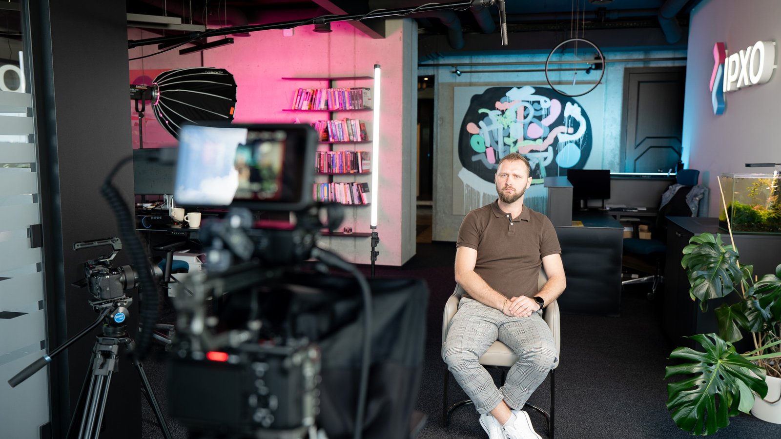 Corporate interview shoot on an IPXO-branded set with full camera setup